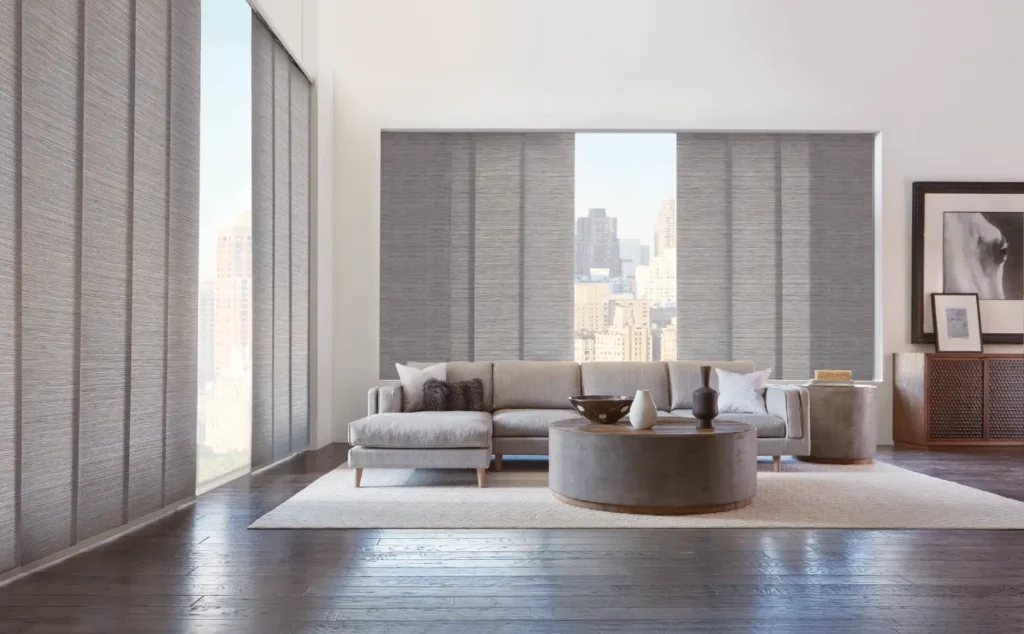 Two large windows covered with skyline gliding panel hunter douglas designer roller shades mounted inside and split stack